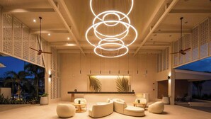 A spacious lobby with a modern chandelier, comfortable seating, and a large window overlooking the outdoors. - Lalynn Resort & Villas (Thep Krasattri)