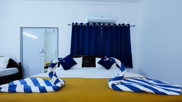 Ein Hotelzimmer mit Bett, Schrank, Vorhang und Klimaanlage.