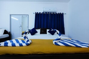 Een hotelkamer met een bed, een kledingkast, een gordijn en een airconditioning.