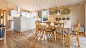 A modern kitchen with wooden cabinetry, a central island, and pendant lighting. - "Efka" - 600m to the fjord by Interhome (Tarm)