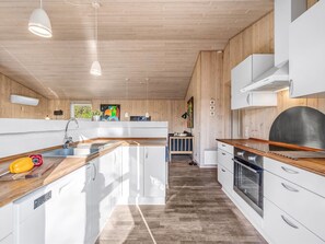 Kjøleskap, ovn, oppvaskmaskin og høy barnestol