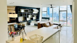 A modern living room with a sofa, dining table, and kitchen area.