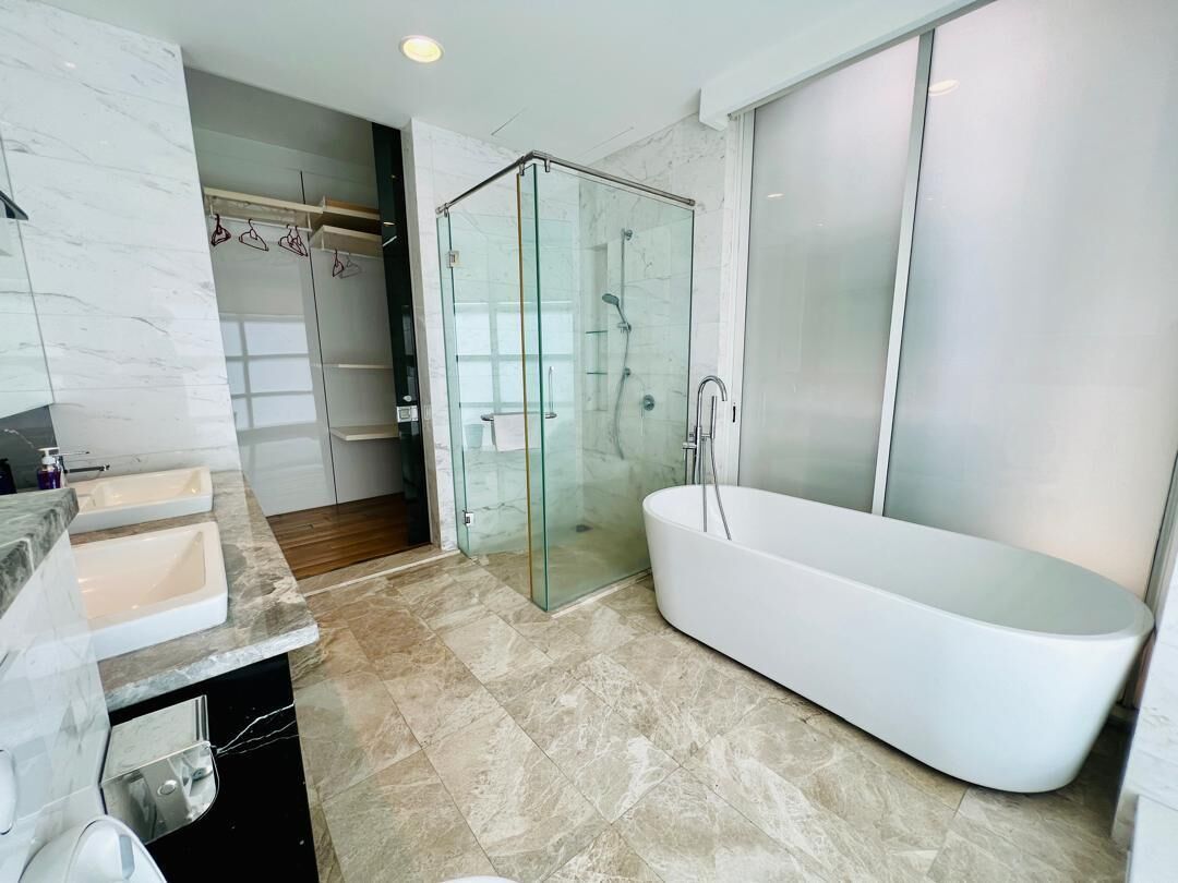 A modern bathroom with a glass-enclosed shower, a freestanding bathtub, and a vanity with a sink.