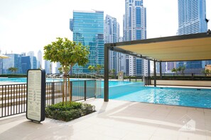 A modern swimming pool area with a city skyline in the background. - Exclusive Burj Crown 4b Balcony City Views (Dubai)