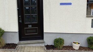 Uma porta preta com o número 38, um pequeno vaso de planta e uma placa indicando um 'Ferienwohnung' (casa de férias) no Eschbach Hof.