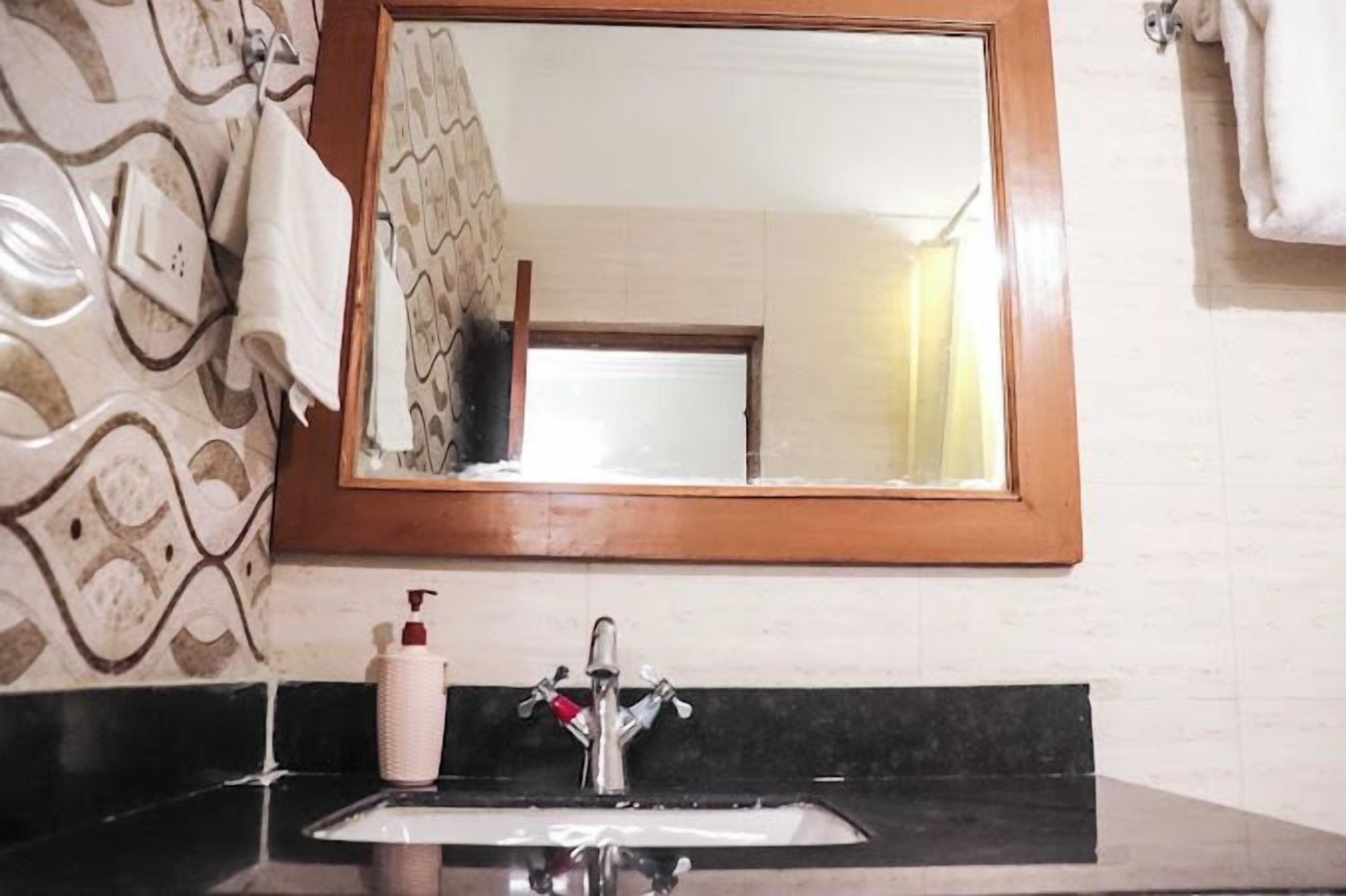 A bathroom with a sink, mirror, and towel rack.