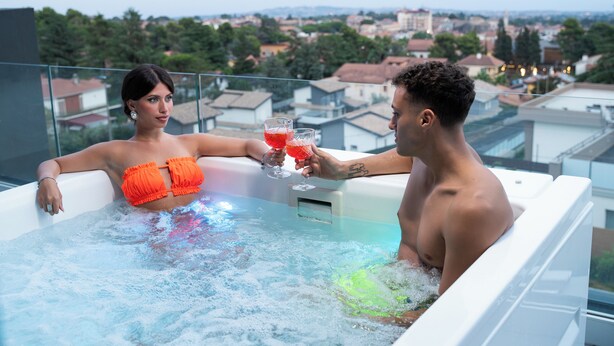 A couple in a hot tub with a cityscape view. - Mon Luxury Rooms - Spa (Nicolosi)