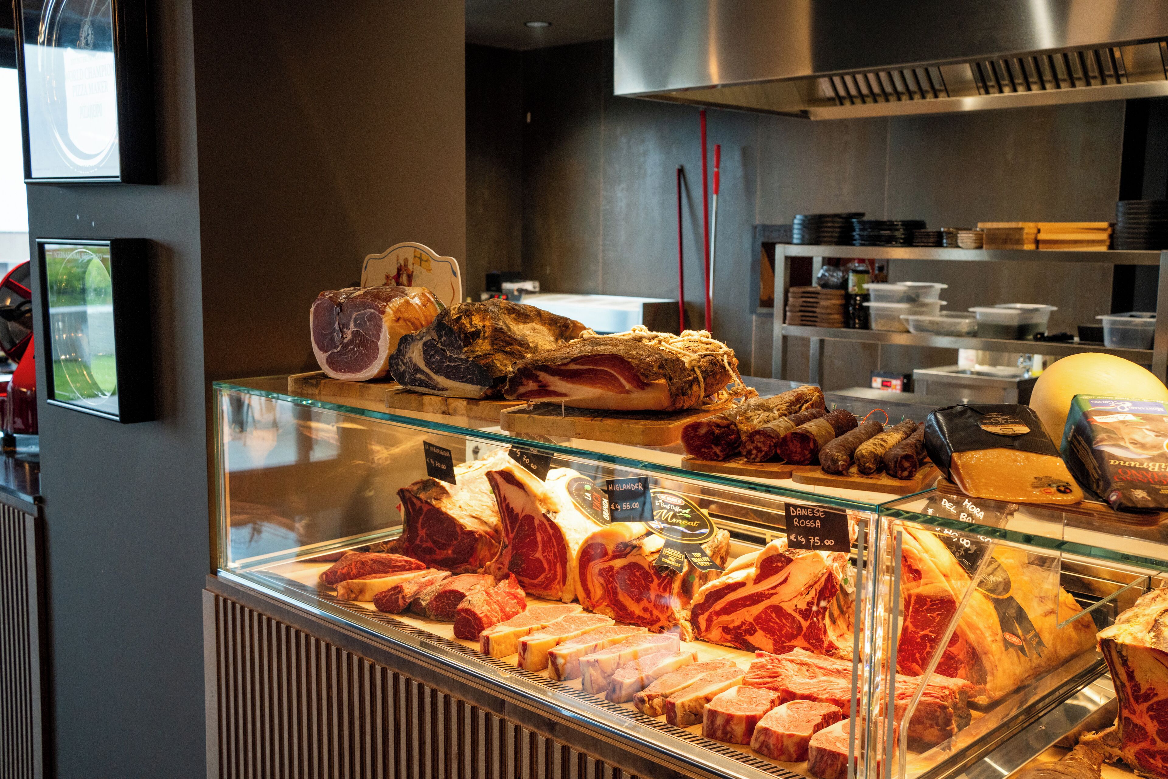 A meat display case in a restaurant with various cuts of meat and a price tag.
