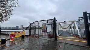 Cross the pedestrian bridge over the water, offering a convenient path to the city.
