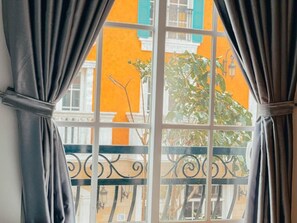 Habitación cuádruple Deluxe, vistas a la ciudad | Zona de estar | Televisión de 25 pulgadas con canales por cable