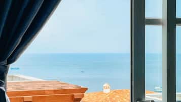 Habitación cuádruple Deluxe, balcón, vistas a la playa | Terraza o patio