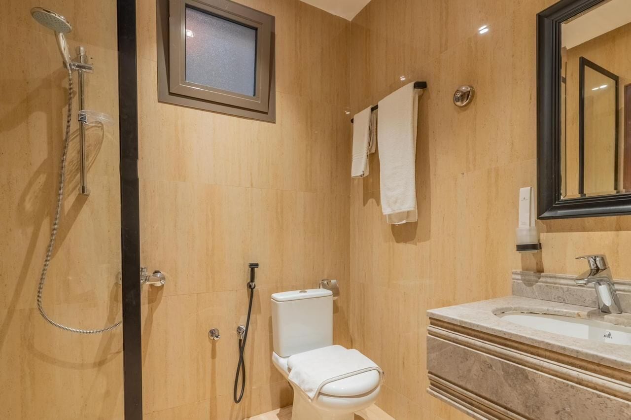 A bathroom with a shower, toilet, and sink.