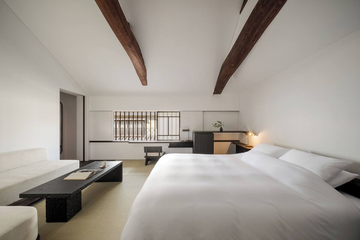 Et moderne hotelværelse med en stor seng, et skrivebord og et siddeområde.