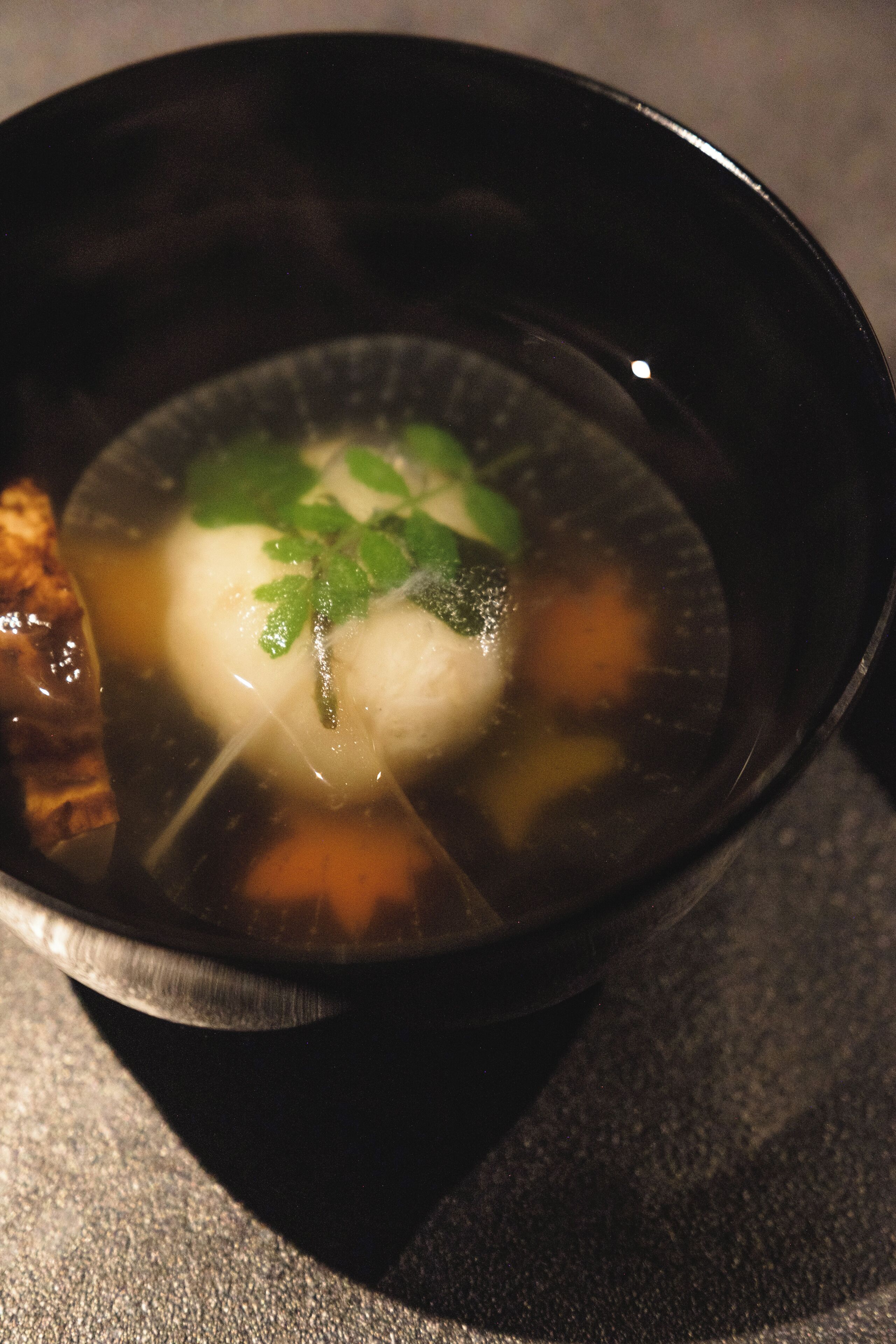 A bowl of soup with noodles, meat, and vegetables.