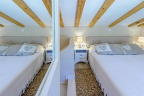 Een spiegelbeeld van een slaapkamer met een bed, nachtkastjes en een lamp.