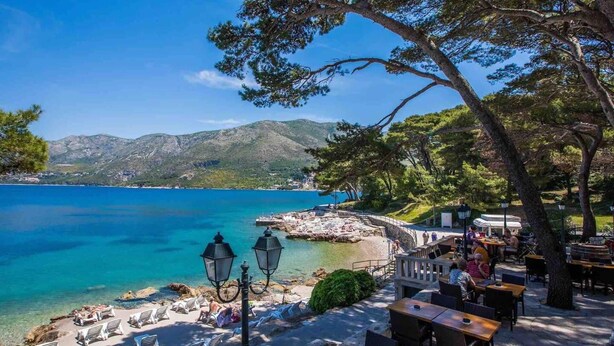 A coastal area with outdoor seating and a view of the sea and mountains. - Cavtat Cozy Retreat Close to Beach (Konavle)