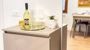 A minibar with a bottle of Astoria wine, two glasses, a decorative tray, and a small potted plant. - C A L I by Ca-sa Check (Chioggia)