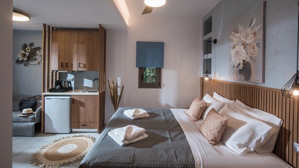 Une chambre à coucher moderne avec un lit, une table de chevet et une vue sur la cuisine.