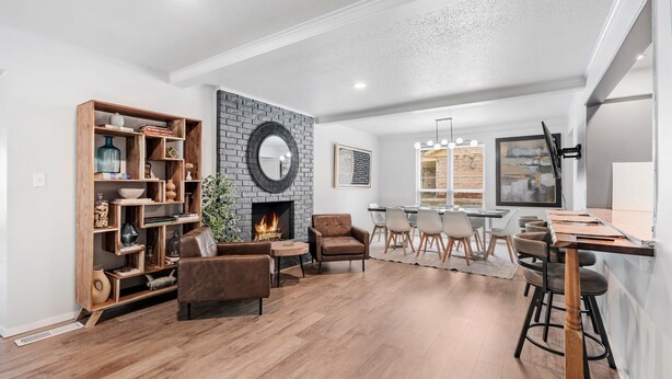 A spacious living area with a fireplace, wooden shelving, leather chairs, and a dining area with bar stools. - Spacious Retreat 8 Bedroom River (Bethany)