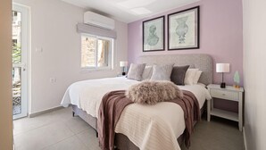 A bedroom with a bed, bedside tables, a window, and wall art. - HaHavatselet 19 - Isrentals - Superior 5 (Jerusalem)