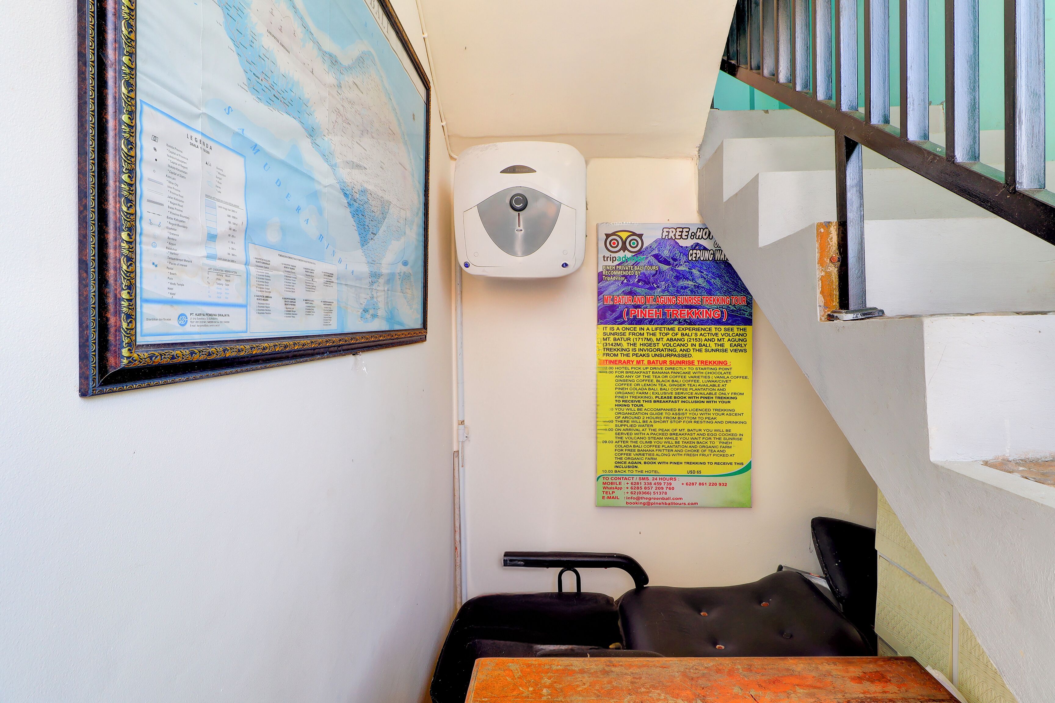 Une petite pièce avec une carte, une affiche et une chaise.