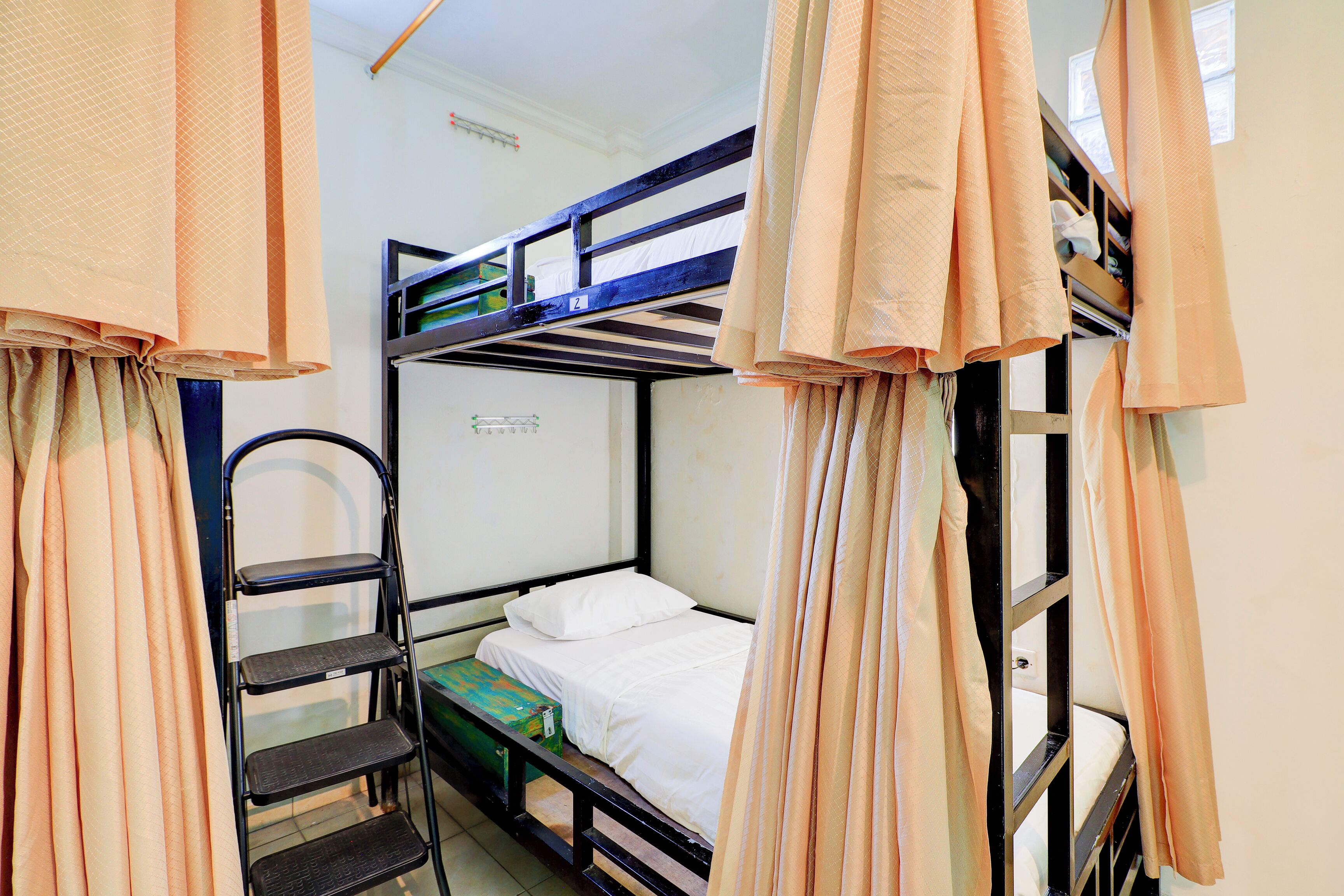 A bunk bed room with a ladder and a small table.