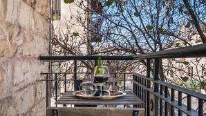 A balcony with a table set for two, featuring a wine bottle and glasses. - baraca boutique (Jerusalem)