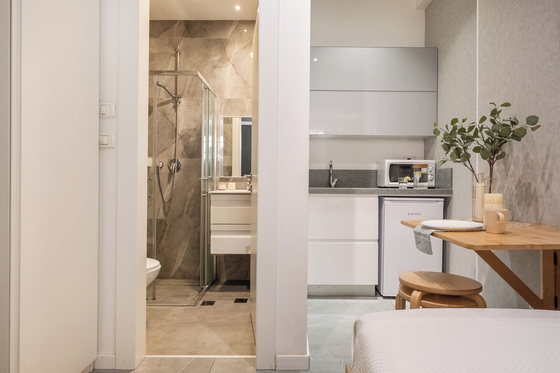 A modern bathroom with a glass-enclosed shower, a toilet, and a sink.