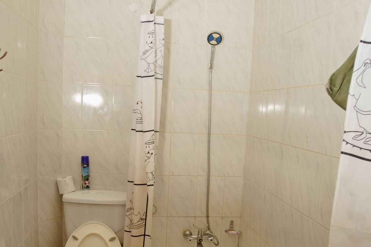 A bathroom with a toilet, a bathtub, and a shower.