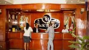 A reception desk with a sign reading "The Tick Hotel". - Tick Hotel (Kampala)