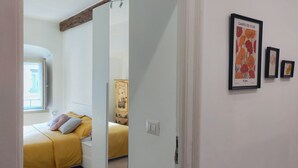 A bedroom with a bed, a wardrobe, and a window. There are framed pictures on the wall. - Conte Verde 8 by Wonderful Italy (Turin)