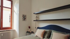 A bedroom with a bed, a radiator, a window, and a wall-mounted shelf. - Conte Verde 10 con Balcone by Wonderful Italy (Turin)