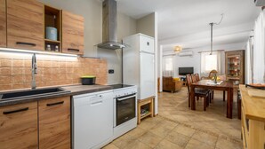 A modern kitchen with wooden cabinets, a built-in oven, and a dishwasher.