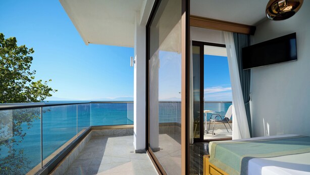 Un balcon doté d’une balustrade en verre donnant sur une étendue d’eau.