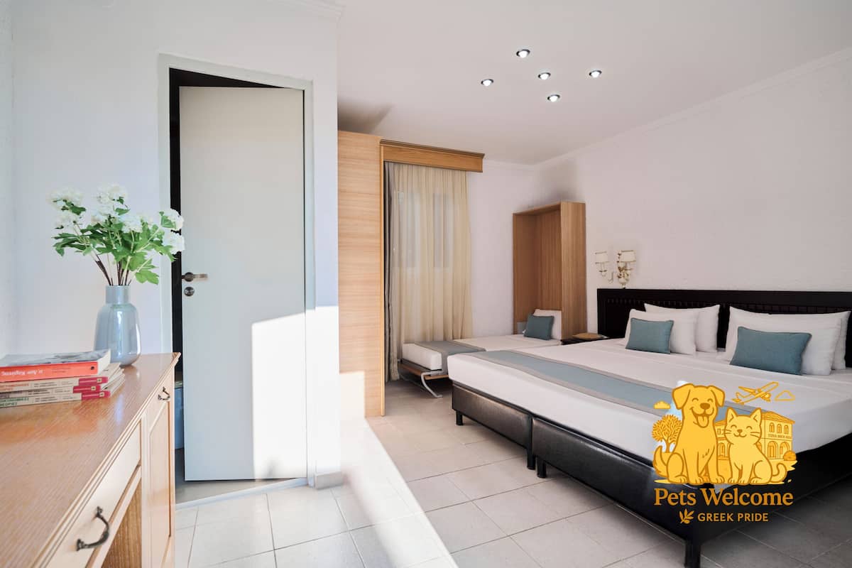 A modern hotel room with a large bed, bedside tables, a desk, and a window with curtains.