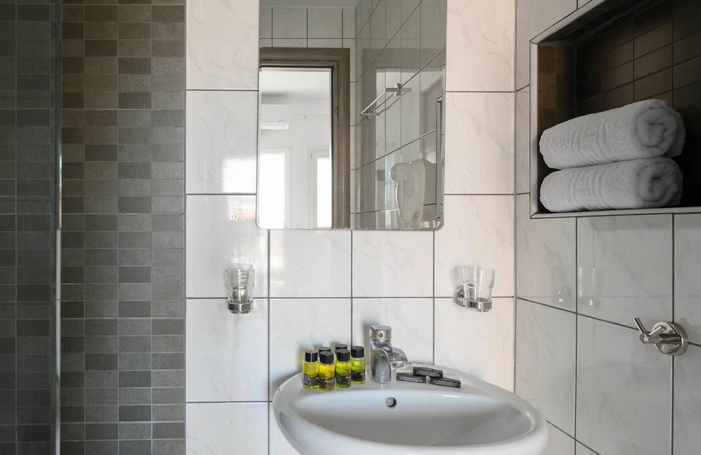 A bathroom with a white sink, mirror, and towel rack.