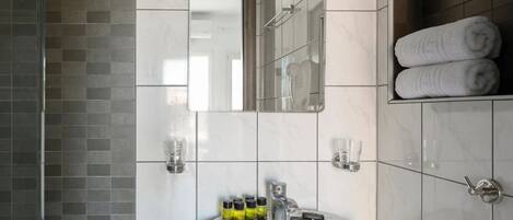 A bathroom with a white sink, mirror, and towel rack.