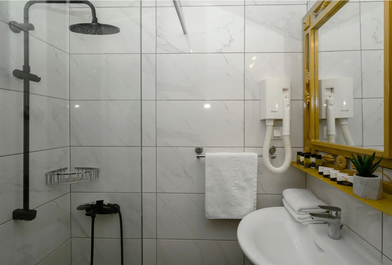 Un baño moderno con ducha, inodoro, lavamanos y tocador con espejo.