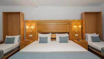 Una cama doble con cabecera de madera, dos mesitas de noche con lámparas y un mueble auxiliar a juego a cada lado.