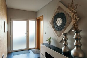 Experience the seamless blend of modern and traditional design elements in this stylish space, featuring a sliding glass door, decorative wall art, and a cozy textured rug.