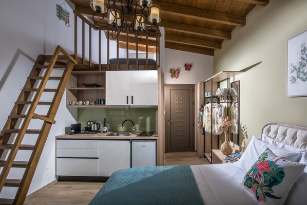 A bedroom with a bed, a dresser, a nightstand, a lamp, and a window.
