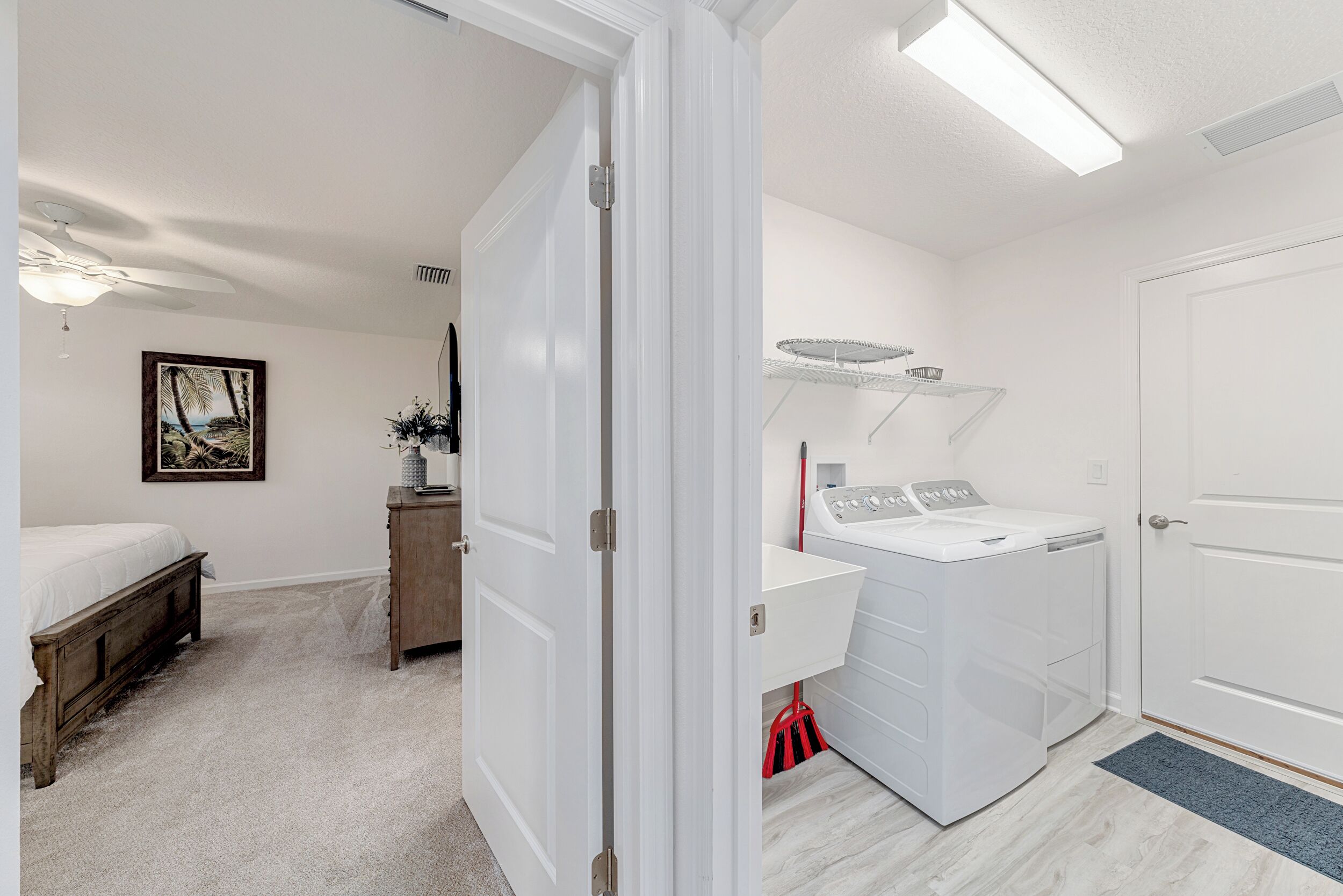 A laundry room with a washing machine, dryer, and a small cabinet.