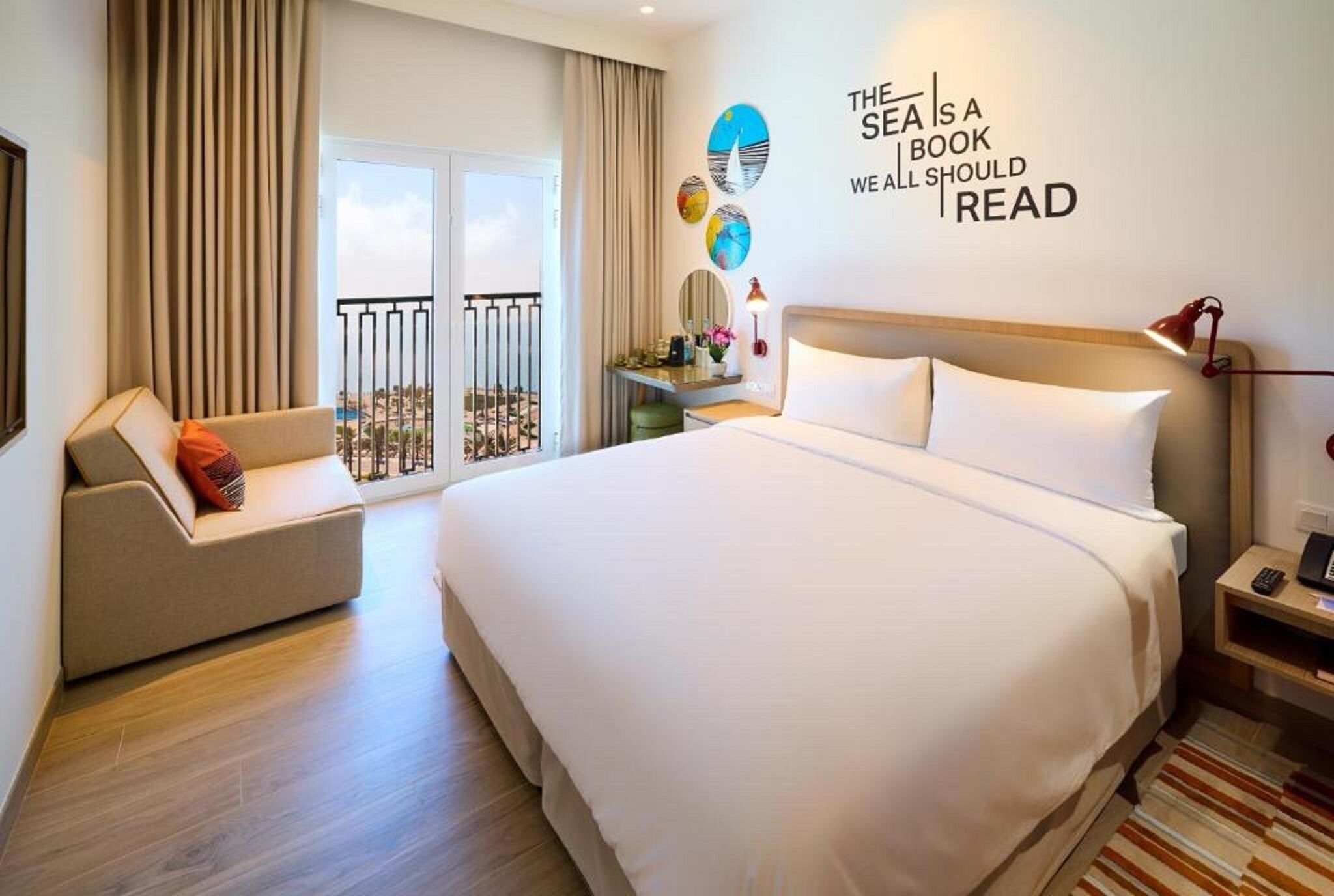 Une chambre d’hôtel avec un grand lit, un canapé, un bureau et un balcon avec vue.