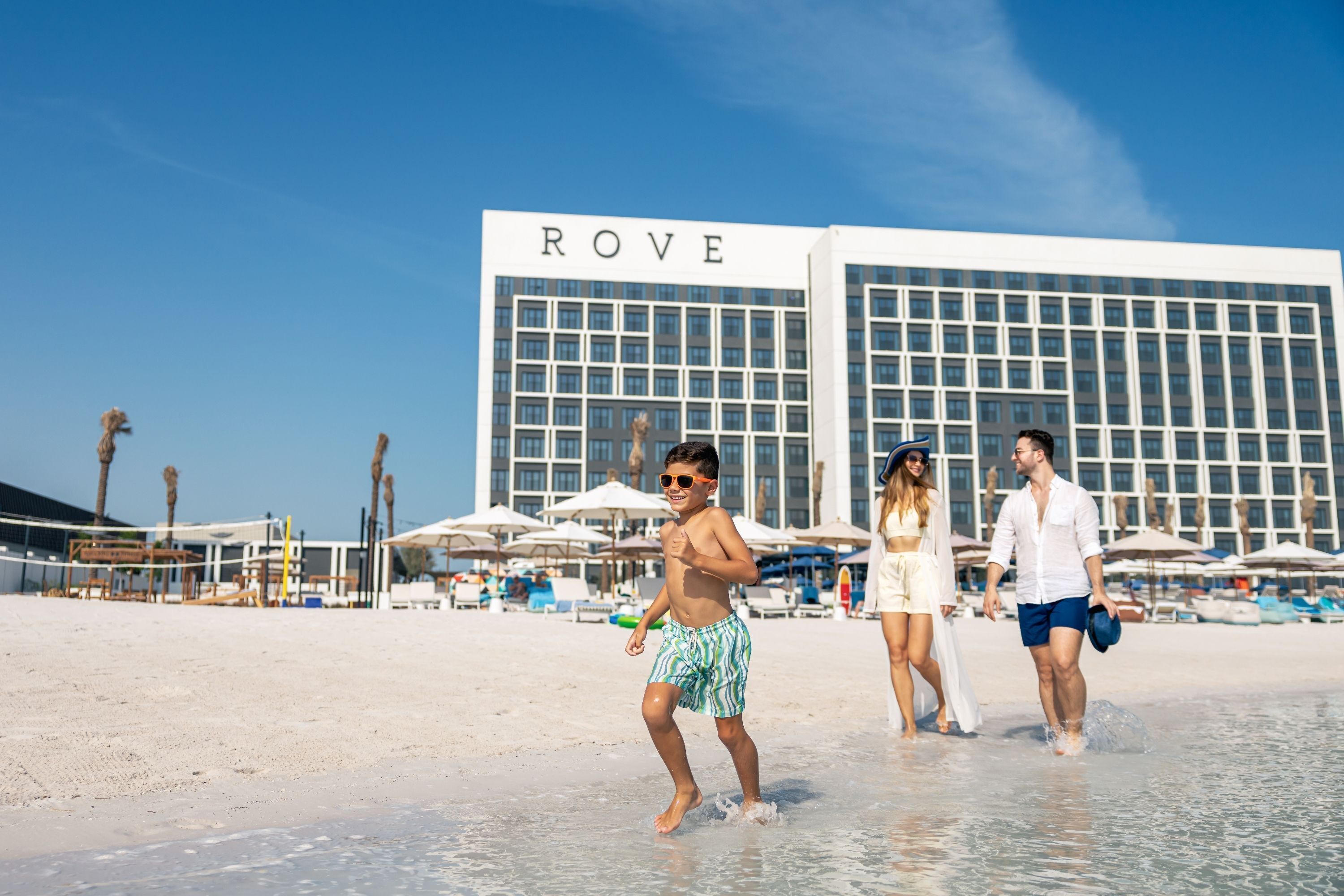 A beach scene with a hotel named 'ROVE' in the background.