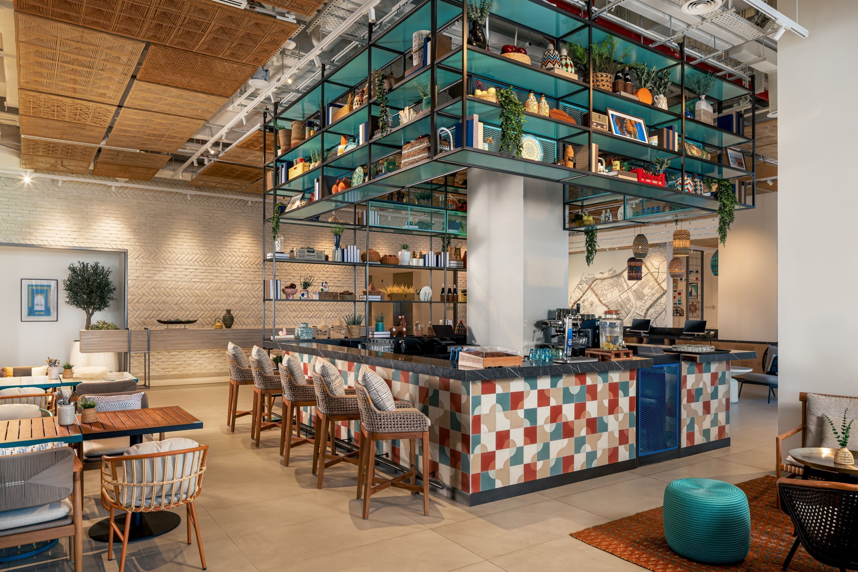 A modern bar area with a checkered tile bar counter, multiple seating options, and a variety of decorative items on shelves.