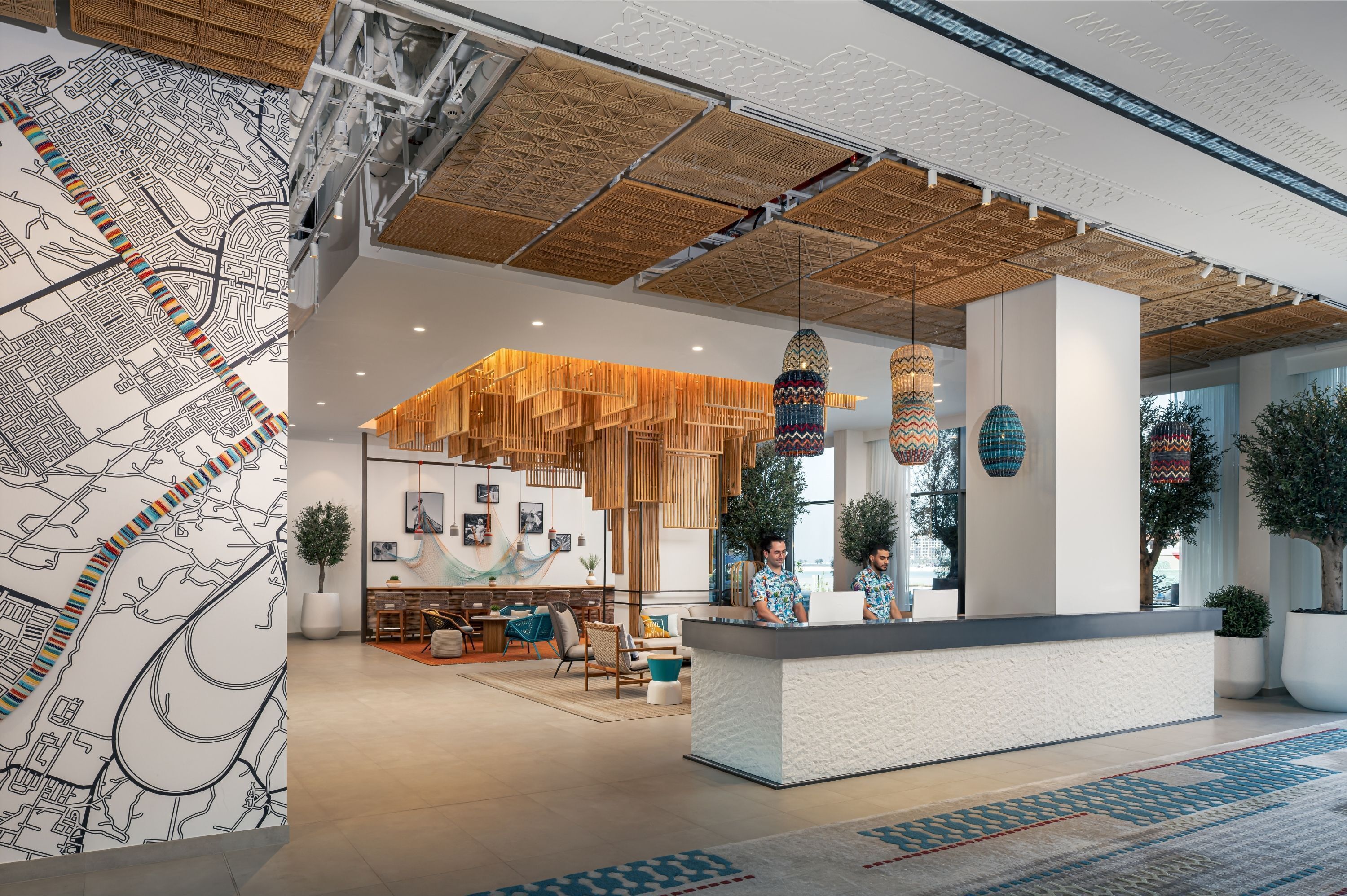 Um lobby de hotel moderno com balcão de recepção, área de estar e um grande mapa mural.