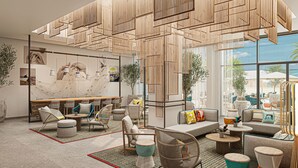A modern interior with a high ceiling, bamboo slats, and a large window offering a view of the outdoors. - Rove Al Marjan Island (Ras Al Khaimah)