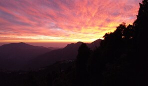 A mountainous landscape with a sunset. - Dev Bhoomi Resort (Tehri)