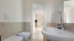 Une salle de bain moderne avec un grand lavabo, un bidet et des toilettes.