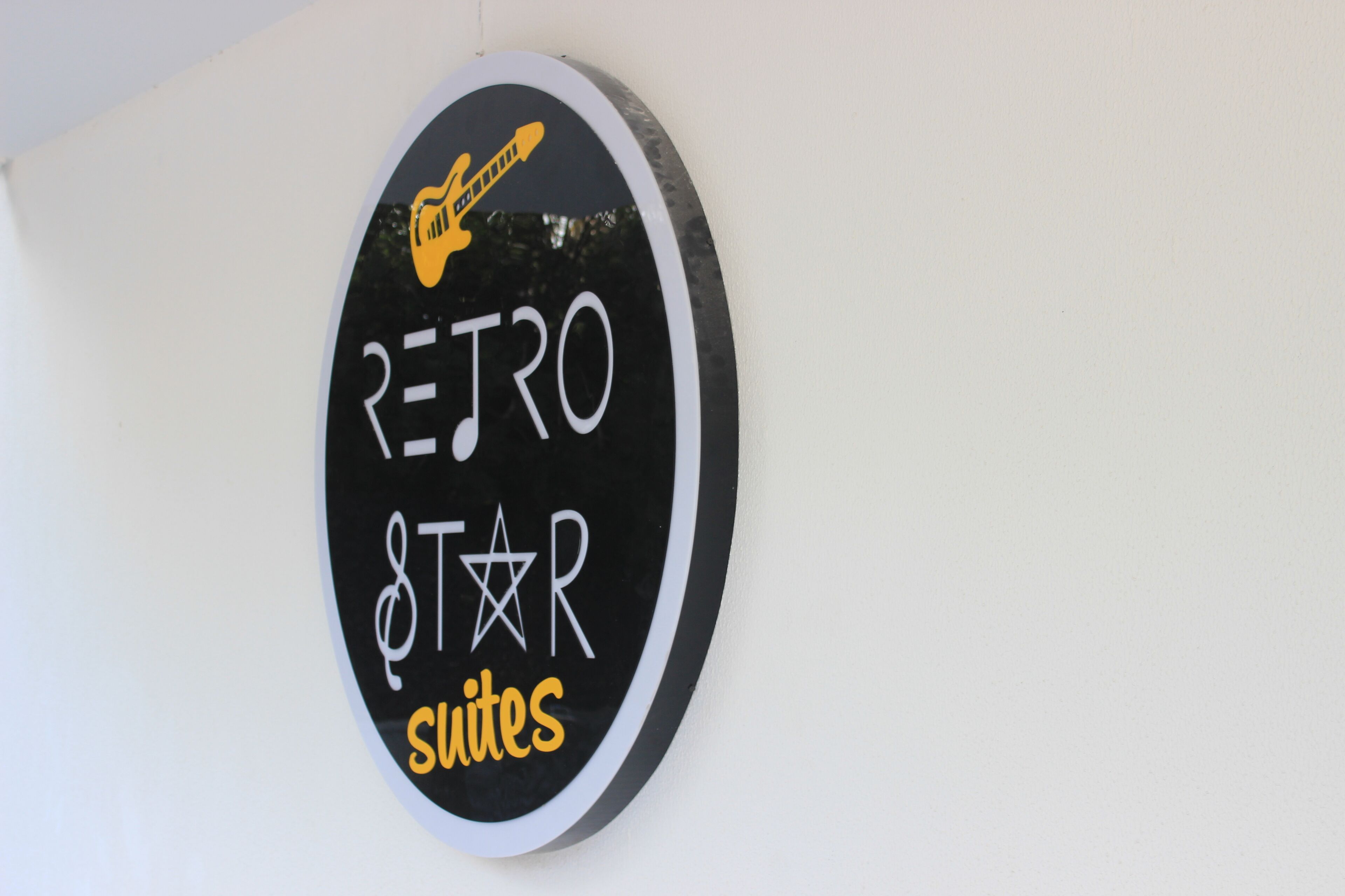 A circular sign with the text "RETRO STAR SUITES" and a guitar icon.